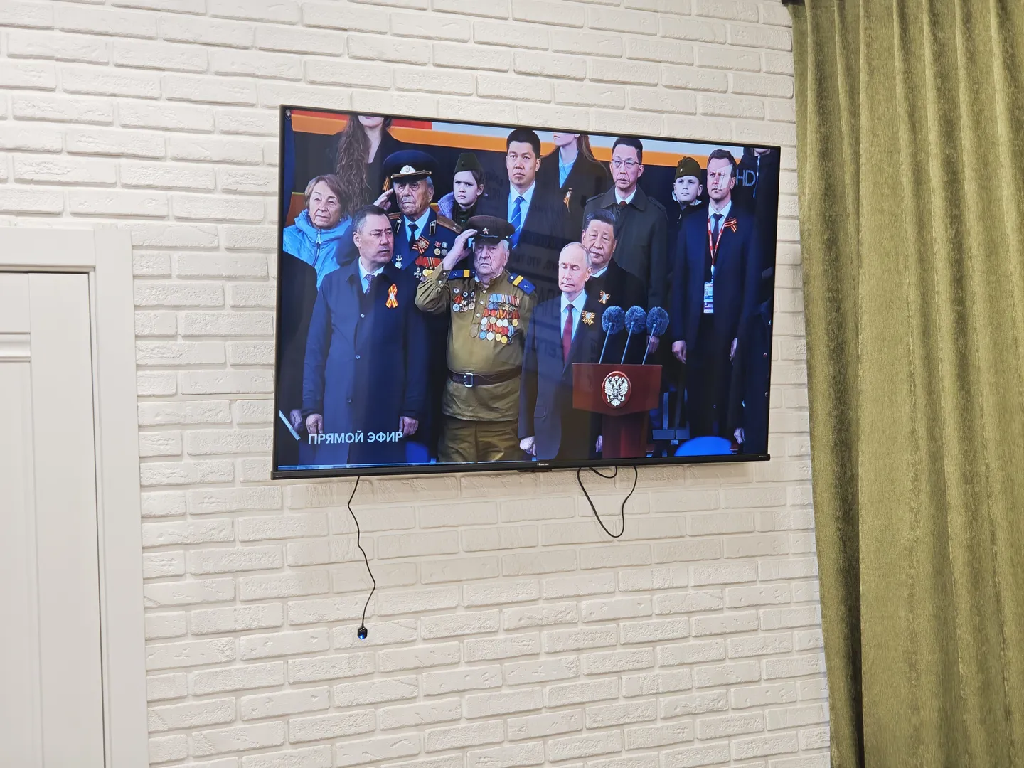旅馆的电视播放着庆祝伟大的卫国战争胜利80周年的阅兵仪式。画面中是国家领导人的合影。